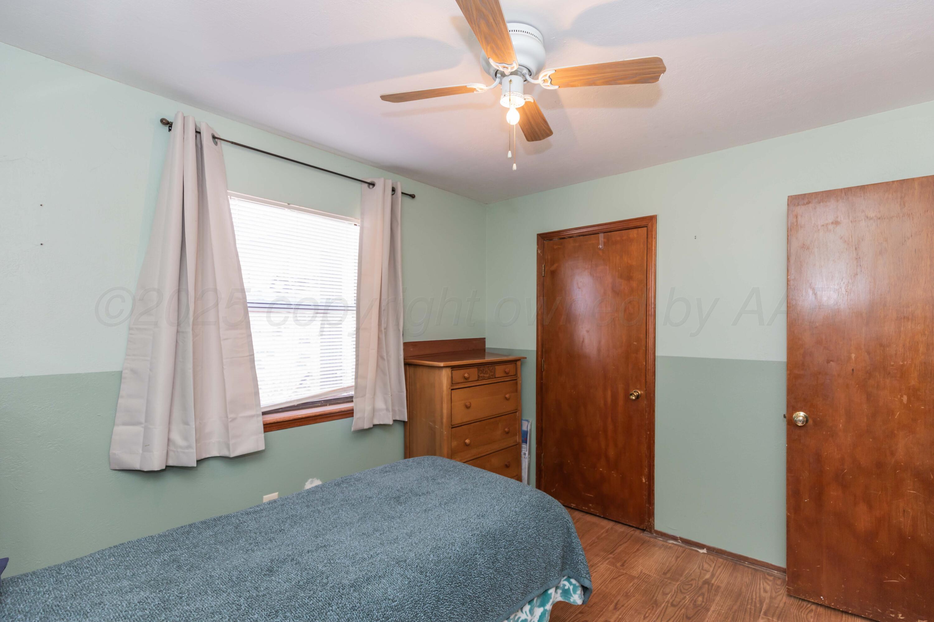 609 Groom Avenue Panhandle, TX 79068 - Photo 19 of 28 a bedroom with a bed and a chandelier