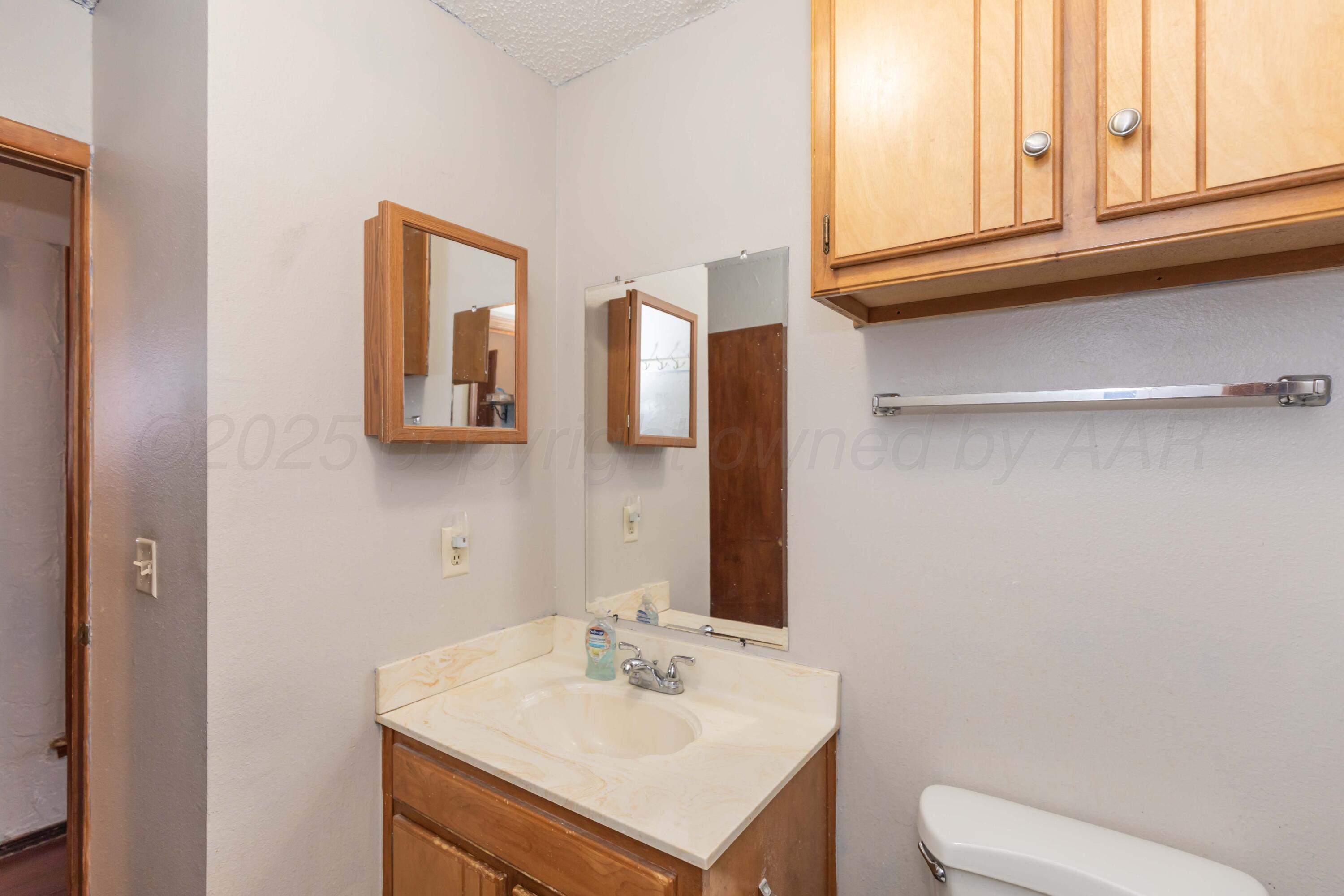 609 Groom Avenue Panhandle, TX 79068 - Photo 22 of 28 a bathroom with a sink a toilet and mirror