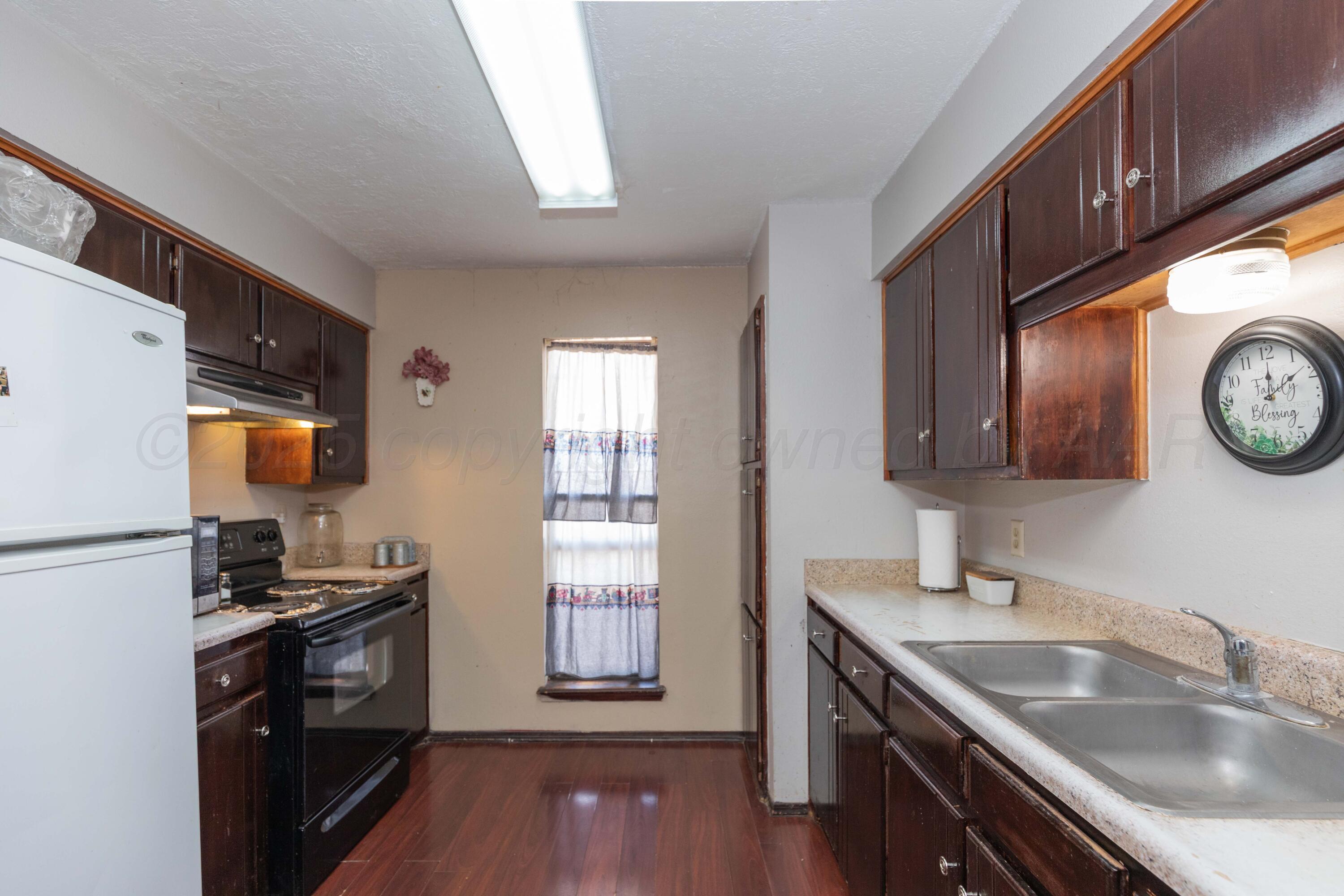 609 Groom Avenue Panhandle, TX 79068 - Photo 4 of 28 a kitchen with a sink stove top oven and refrigerator