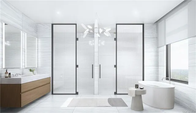 a bathroom with a double vanity sink a mirror and a bathtub