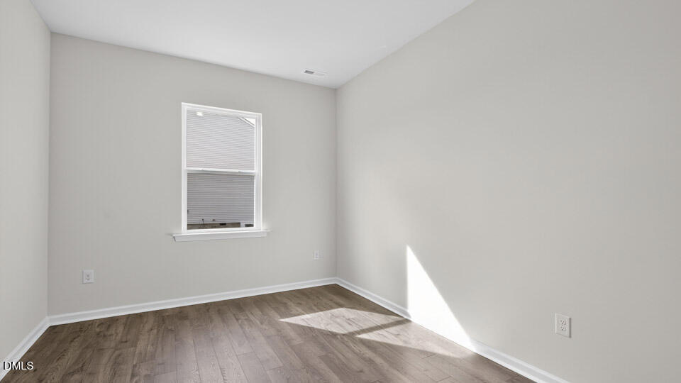 181 Fair Child Road Spring Lake, NC 28390 - Photo 8 of 43 an empty room with wooden floor and windows