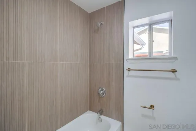 an empty room with fan and windows