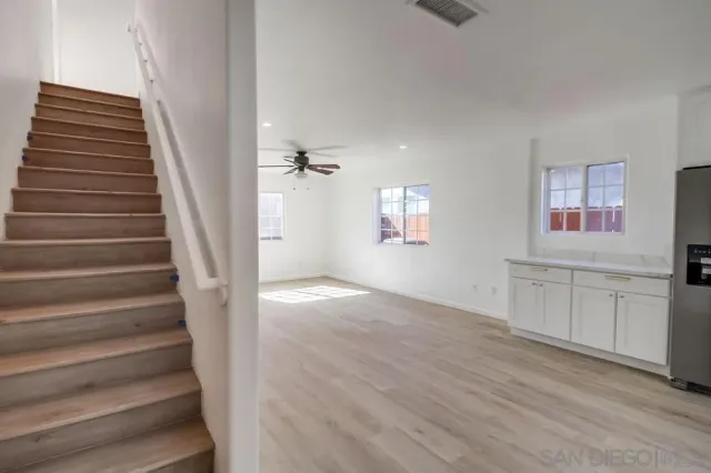 an empty room with a window and a fan