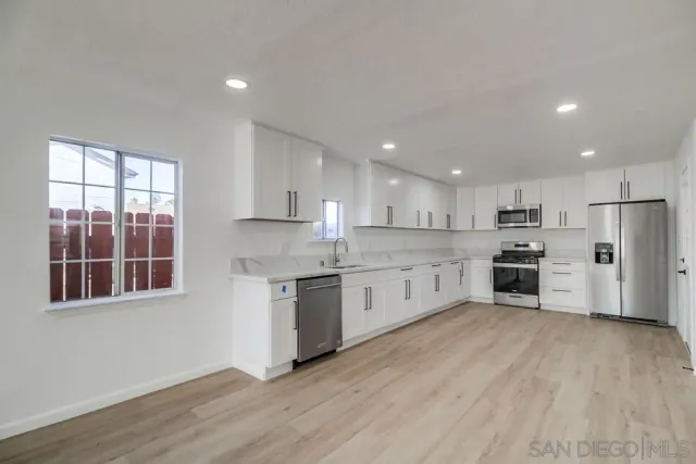 a kitchen with granite countertop white cabinets and white appliances