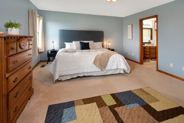 a large bed sitting in a bedroom next to a window