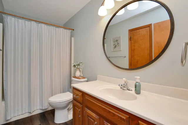 a kitchen with stainless steel appliances granite countertop a refrigerator a sink dishwasher a stove and white countertops with wooden floor