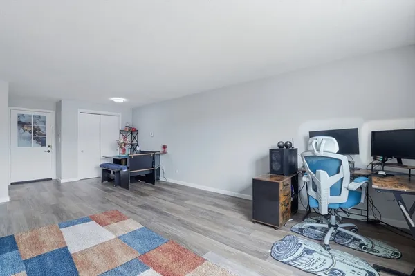 a living room with furniture and a flat screen tv with wooden floor