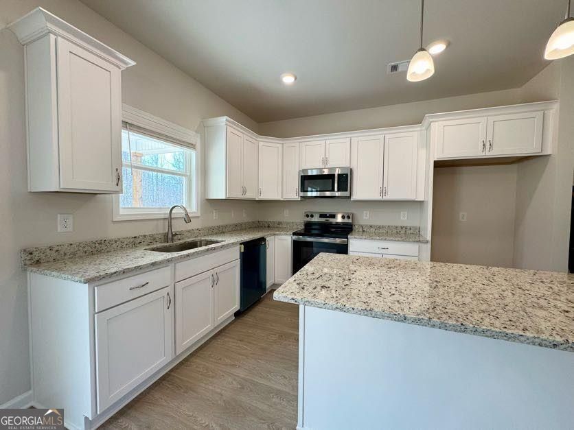 239 Cool Springs Road Clarkesville, GA 30523 - Photo 22 of 37 a kitchen with kitchen island granite countertop a sink window and refrigerator