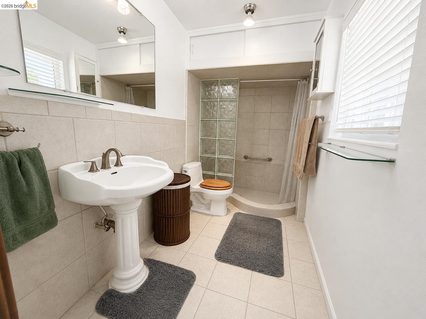 18195 Wards Ferry Road Sonora, CA 95370 - Photo 21 of 67 Bathroom featuring a pedestal sink with brushed nickel fixtures, tiled flooring, and a glass block shower enclosure