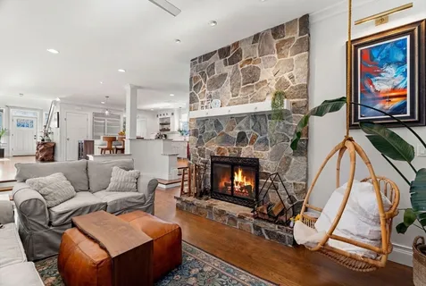 a living room with furniture a flat screen tv and a refrigerator