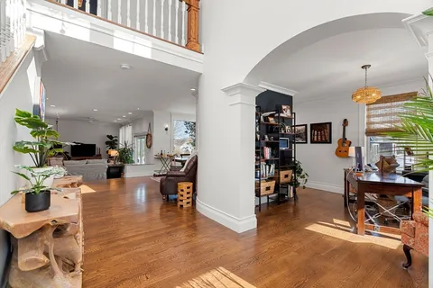 a living room with furniture a flat screen tv and a large window