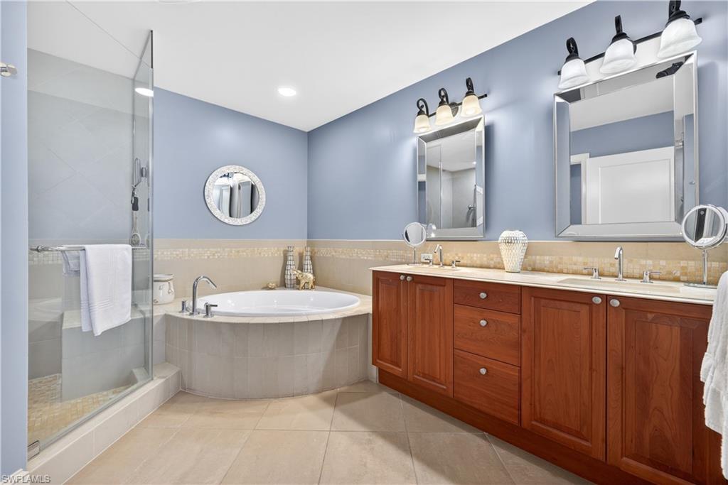 9115 Strada Place, Unit 5504 Naples, FL 34108 - Photo 10 of 22 a bathroom with a tub sink and mirror