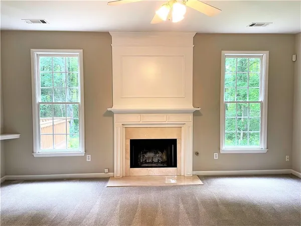an empty room with a fireplace and windows