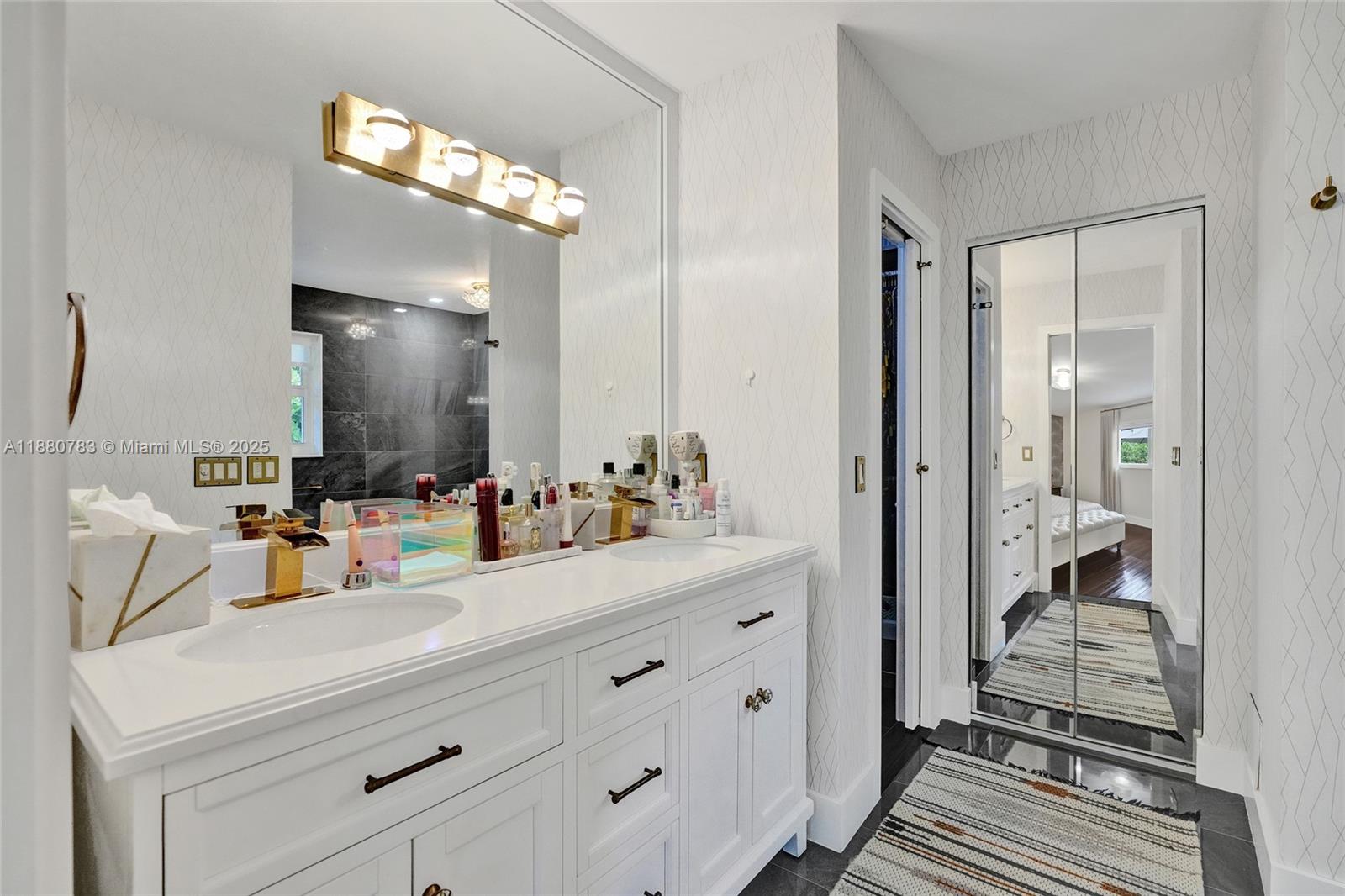 910 Southwest 23rd Road Miami, FL 33129 - Photo 43 of 62 a bathroom with a sink a mirror and a shower