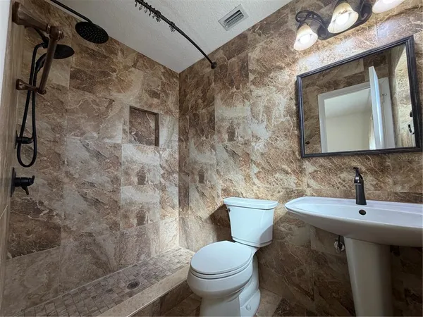 a bathroom with a sink toilet and shower