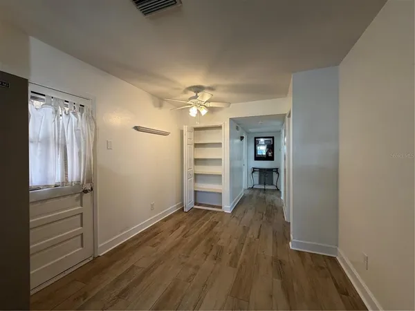 a view of a livingroom with wooden floor closet and window