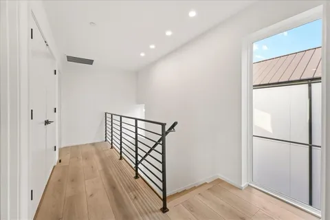 a view of a hallway with wooden floor and staircase