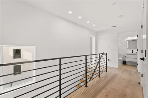a view of empty room with wooden floor and ceiling fan