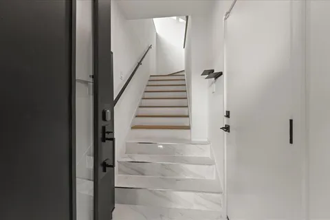 a view of entryway and hall with wooden floor