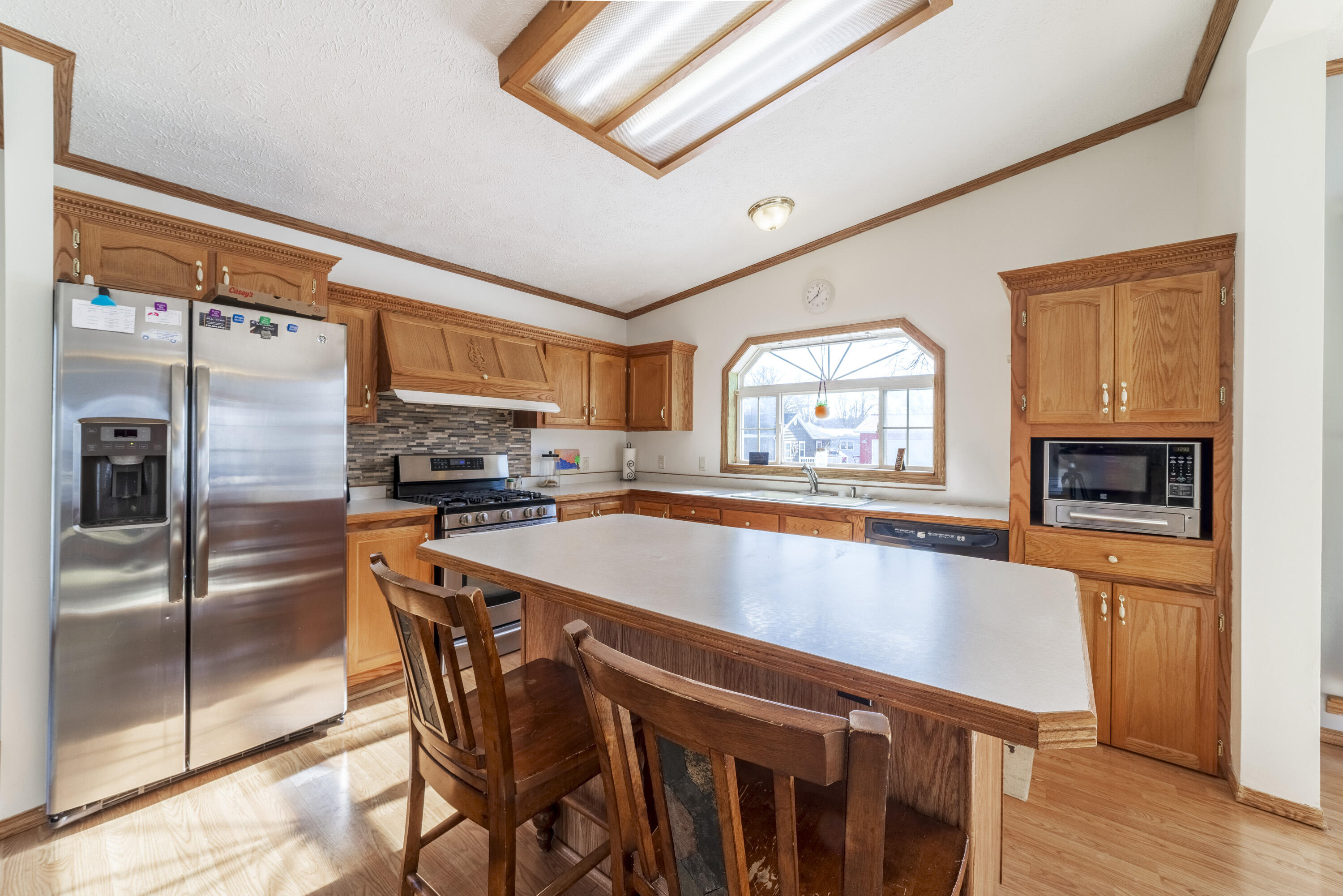 409 South Street Hebron, IN 46341 - Photo 11 of 36 a kitchen with stainless steel appliances granite countertop a refrigerator a stove and a sink with wooden floor
