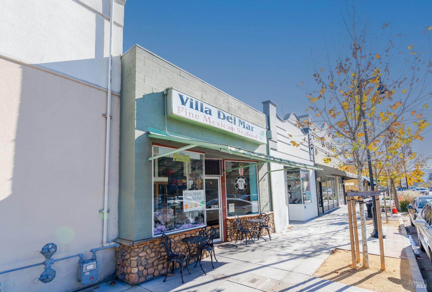a view of a building with retail shops and traffic signal