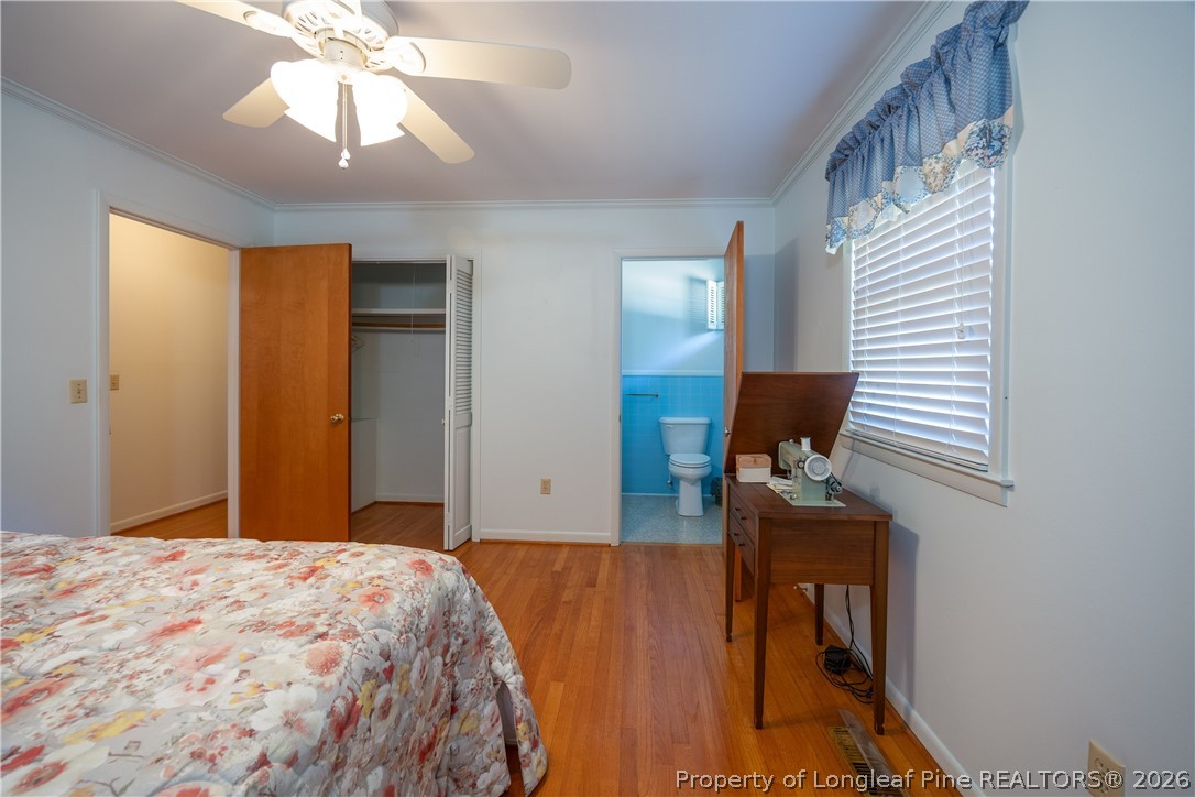 5424 Bonnetsville Road Clinton, NC 28328 - Photo 19 of 29 a bedroom with a bed and a chandelier