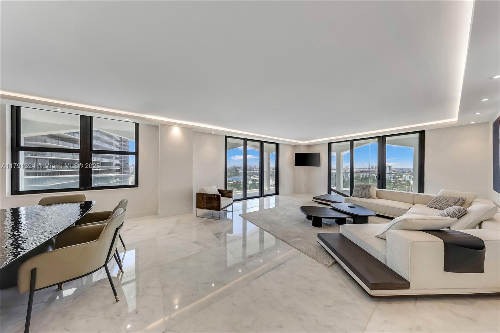 a living room with furniture and floor to ceiling windows