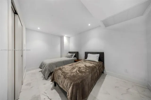 a bedroom with two beds and a lamp