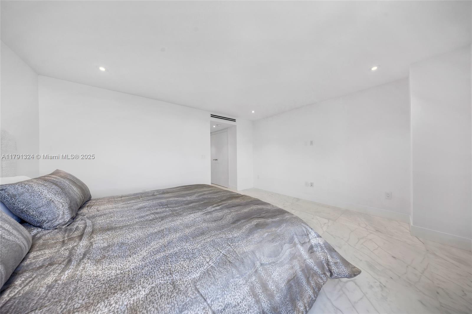 9801 Collins Avenue, Unit 17R Bal Harbour, FL 33154 - Photo 23 of 46 a bedroom with a bed and a window