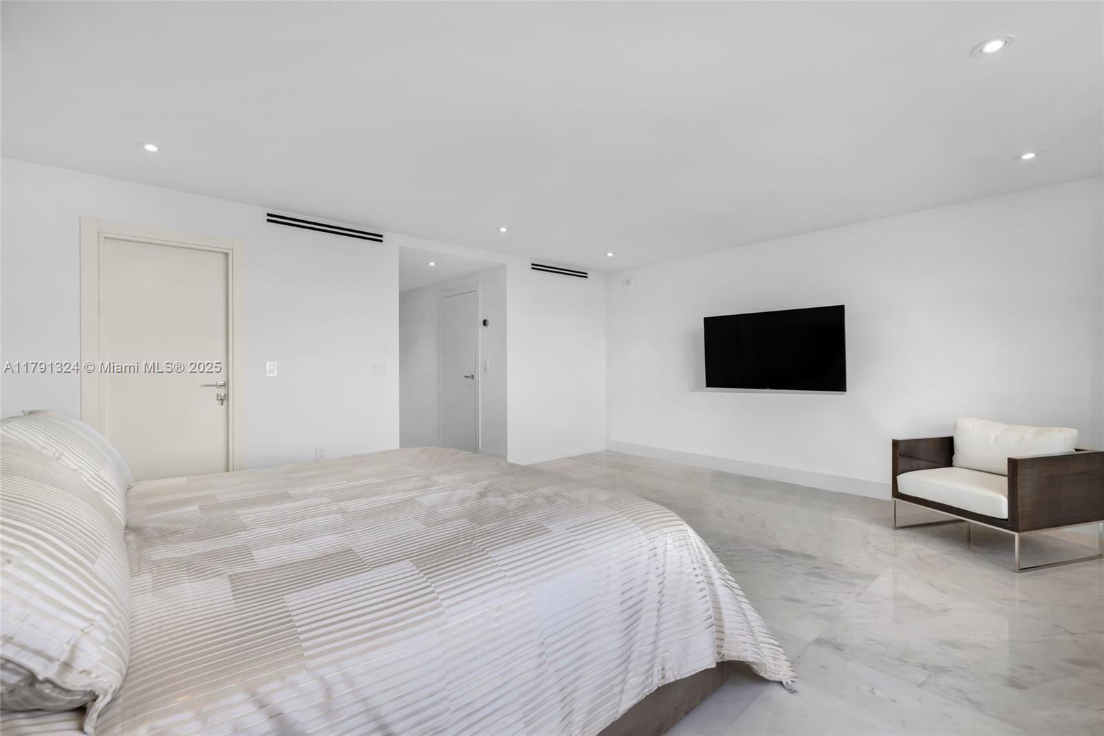 9801 Collins Avenue, Unit 17R Bal Harbour, FL 33154 - Photo 31 of 46 a bedroom with a bed and a flat screen tv