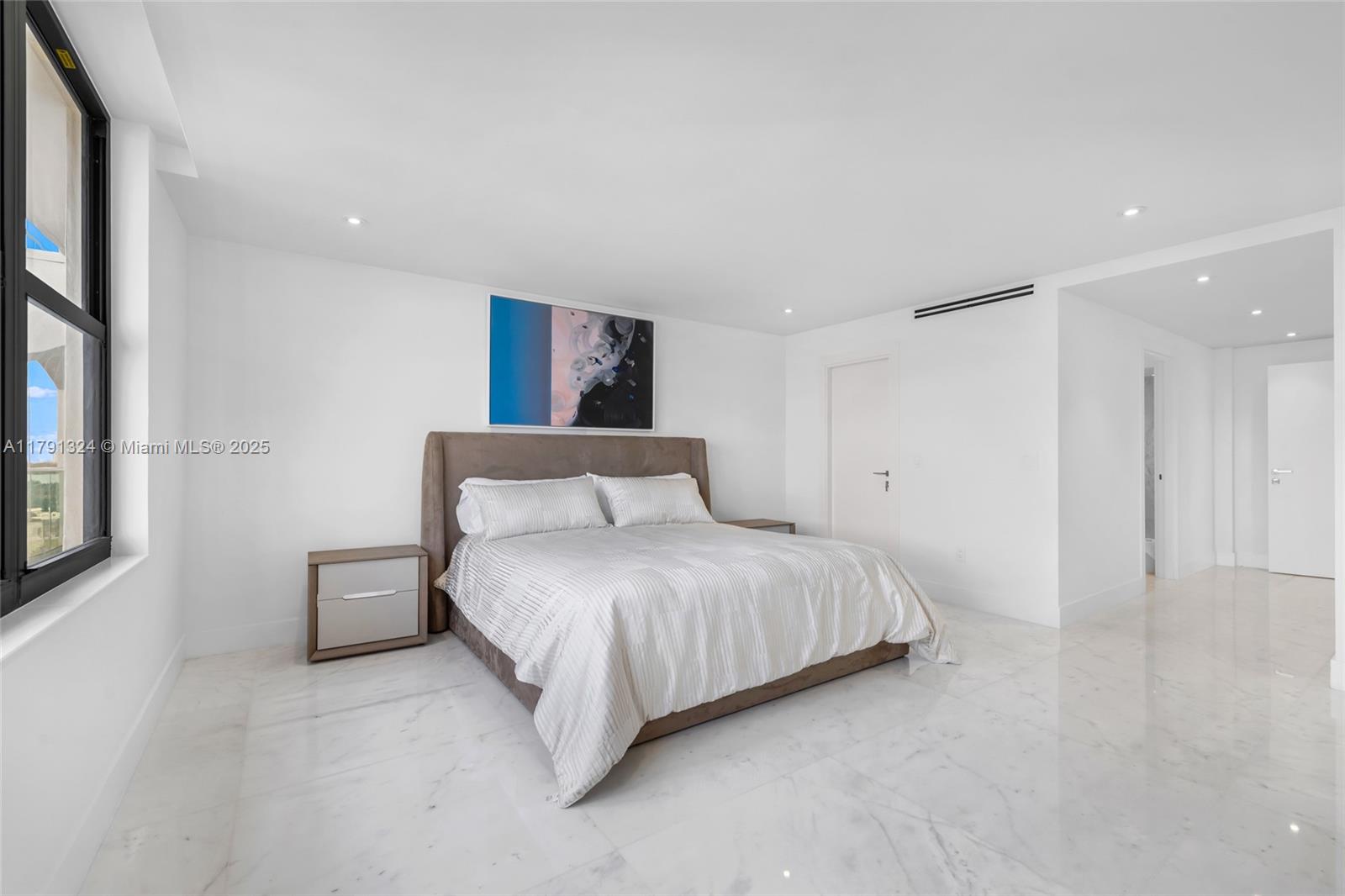 9801 Collins Avenue, Unit 17R Bal Harbour, FL 33154 - Photo 32 of 46 a bedroom with a bed and a night stand
