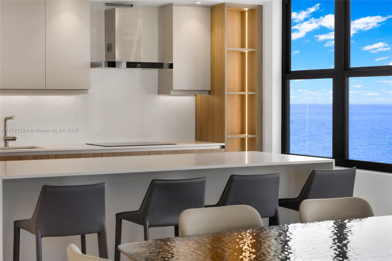 9801 Collins Avenue, Unit 17R Bal Harbour, FL 33154 - Photo 45 of 46 a kitchen with a table chairs cabinets and a window