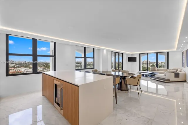 a living room with furniture a large window and kitchen view
