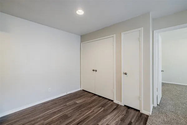a view of an empty room with a window and a kitchen