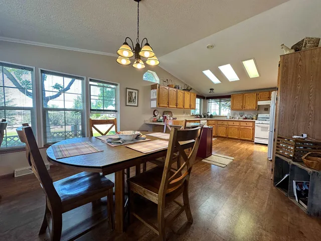 a view of a dining room with furniture a chandelier and wooden floor