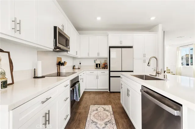 a kitchen with cabinets stainless steel appliances and a sink