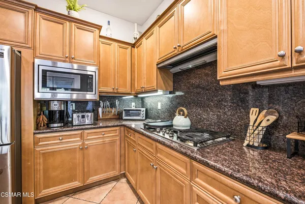 a kitchen with stainless steel appliances granite countertop a sink a stove and cabinets