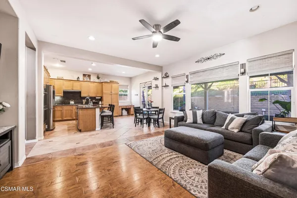 a living room with furniture kitchen view and large windows