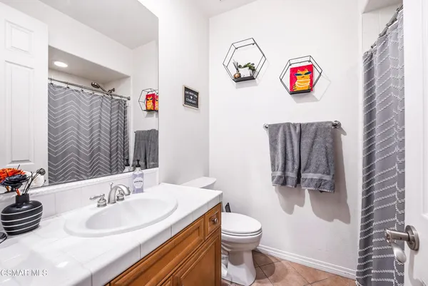 a bathroom with a sink a toilet and a shower curtain