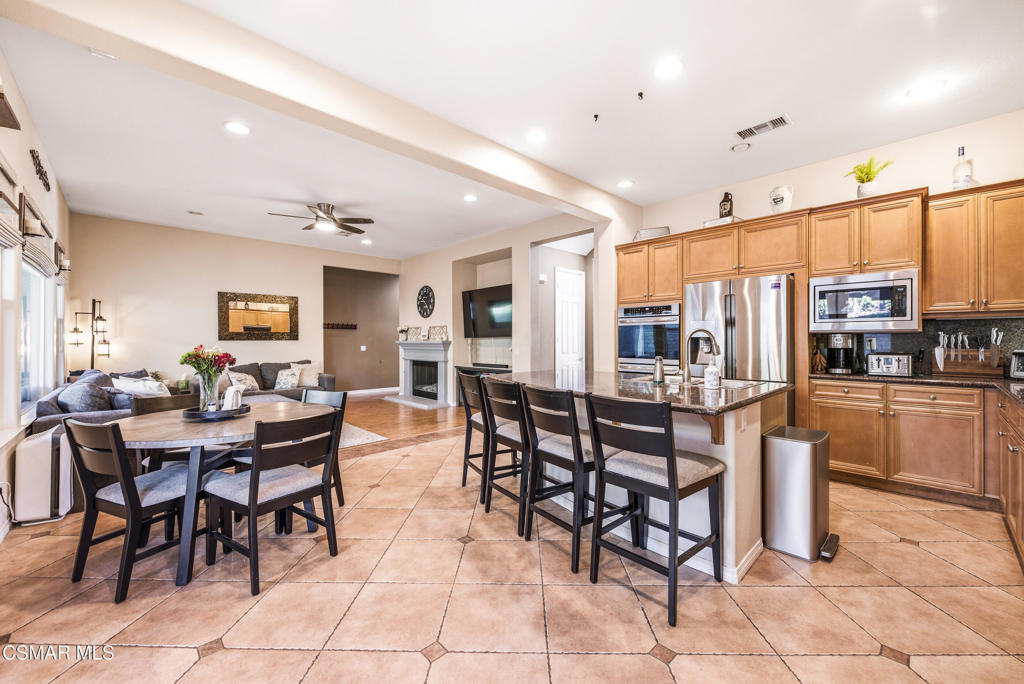 4741 Westwood Street Simi Valley, CA 93063 - Photo 9 of 50 a dining hall with stainless steel appliances kitchen island granite countertop a dining table chairs and view kitchen