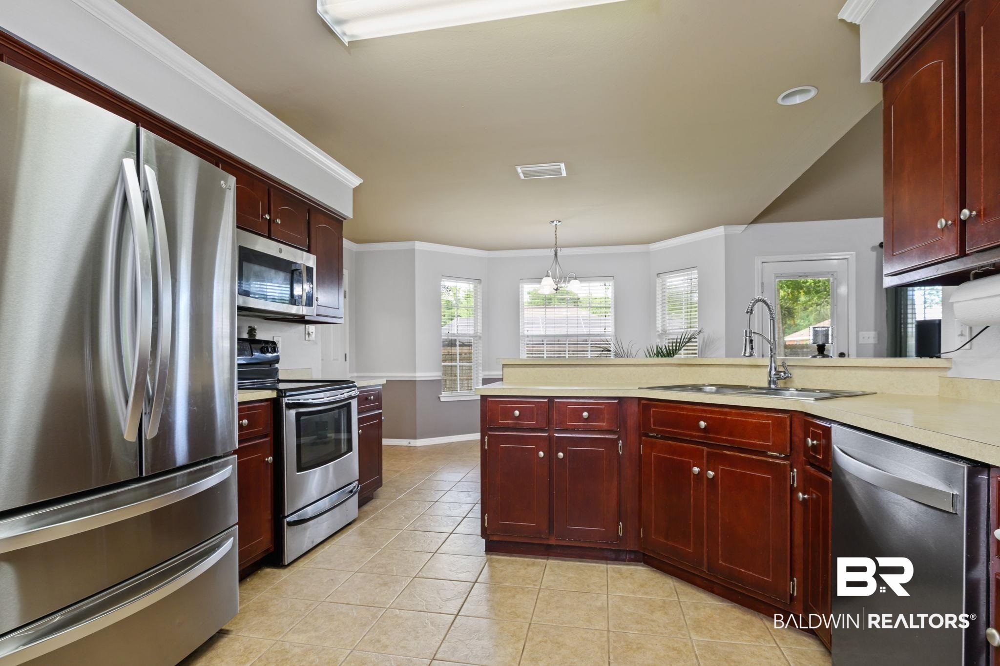 9422 Labrador Run South Mobile, AL 36695 - Photo 12 of 36 Kitchen featuring stainless steel appliances, wood cabinetry, tile flooring, and light-toned countertops
