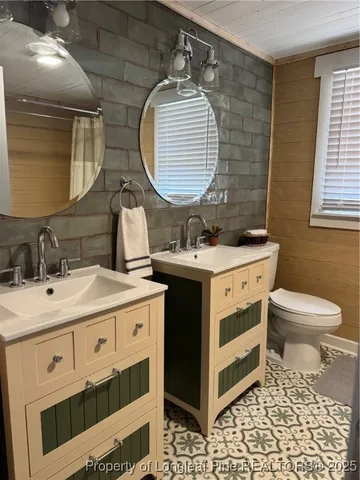 a bathroom with a sink mirror vanity and toilet