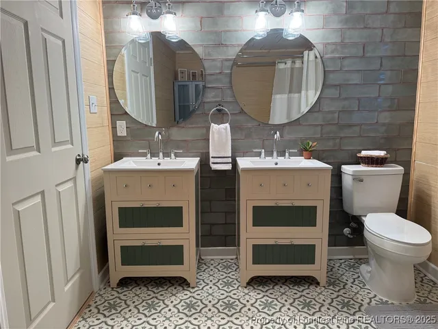 a bathroom with a double vanity sink mirror and toilet