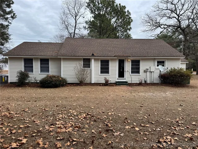 a front view of house with yard and trees around