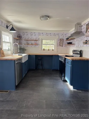 a large kitchen with stainless steel appliances granite countertop a sink and cabinets