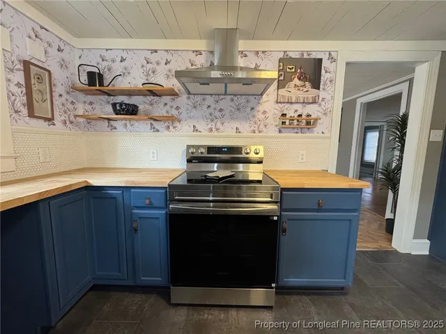 a kitchen with stainless steel appliances granite countertop a stove and a wooden cabinets