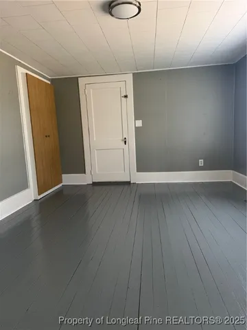 a view of an empty room with wooden floor