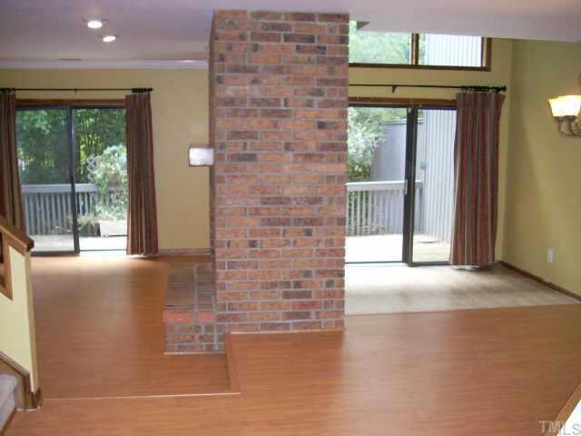 4339 Sunscape Lane Raleigh, NC 27613 - Photo 3 of 10 Living room on left with brick fireplace and dining room on right. Both have sliders to deck.