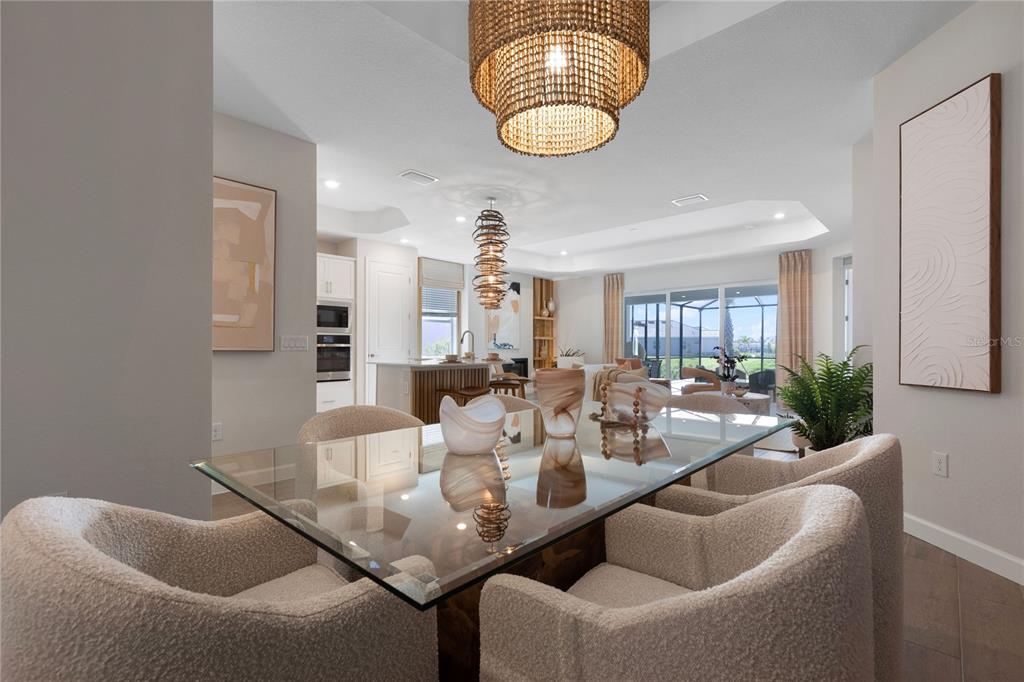 7157 Inlet Isles Lakewood Ranch, FL 34202 - Photo 9 of 26 a view of a dining room with furniture and chandelier