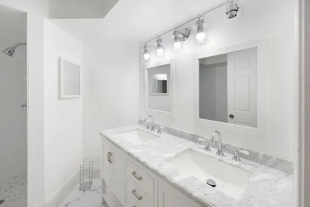 a bathroom with a granite countertop sink double and mirror